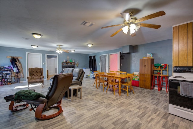 dining room with a ceiling fan, visible vents, and light wood finished floors