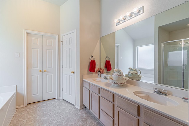 bathroom featuring a sink, a garden tub, a stall shower, and double vanity