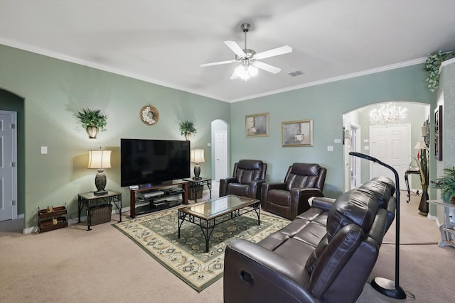 carpeted living area with baseboards, visible vents, arched walkways, ornamental molding, and ceiling fan with notable chandelier