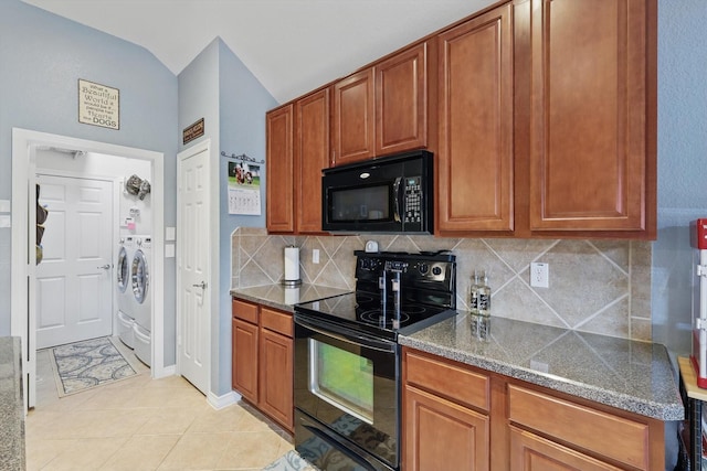 kitchen featuring brown cabinetry, light tile patterned flooring, black appliances, washing machine and dryer, and tasteful backsplash