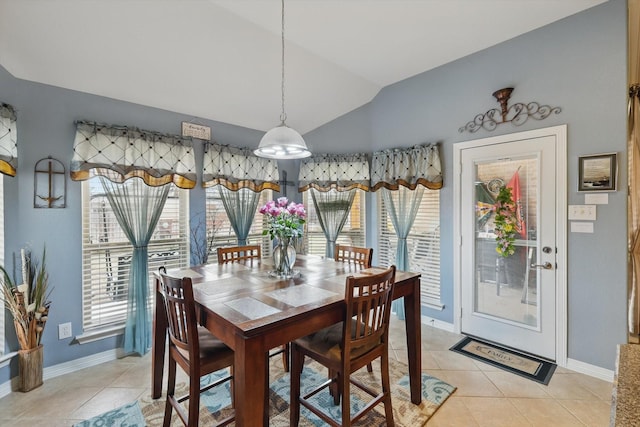 dining room with lofted ceiling, plenty of natural light, and light tile patterned floors