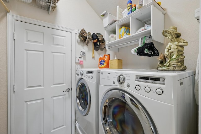 clothes washing area featuring laundry area and washer and clothes dryer