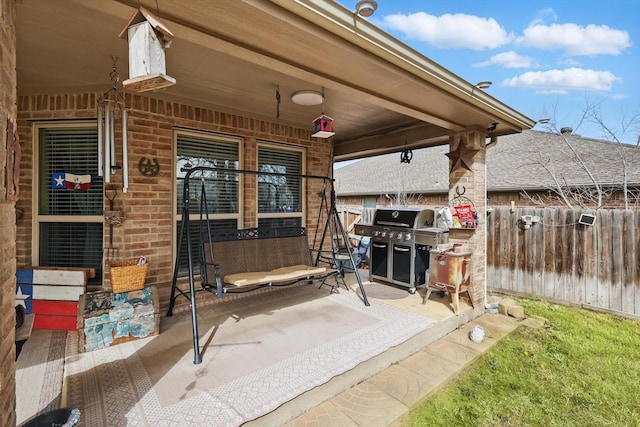 view of patio / terrace featuring a porch, area for grilling, and fence