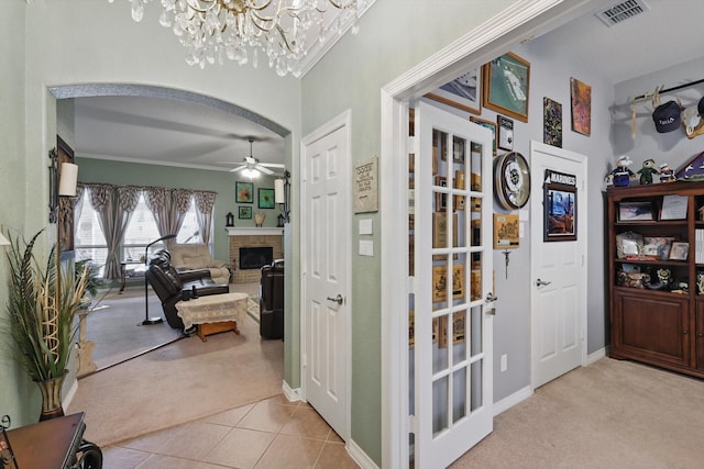 corridor featuring visible vents, arched walkways, carpet flooring, tile patterned flooring, and baseboards