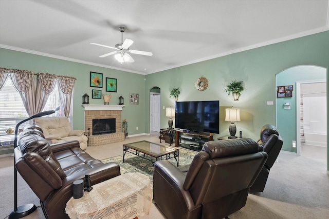 carpeted living area featuring baseboards, arched walkways, ornamental molding, and a fireplace