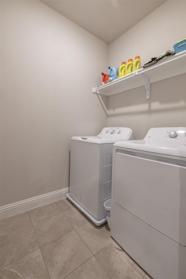 washroom featuring baseboards, independent washer and dryer, light tile patterned flooring, and laundry area