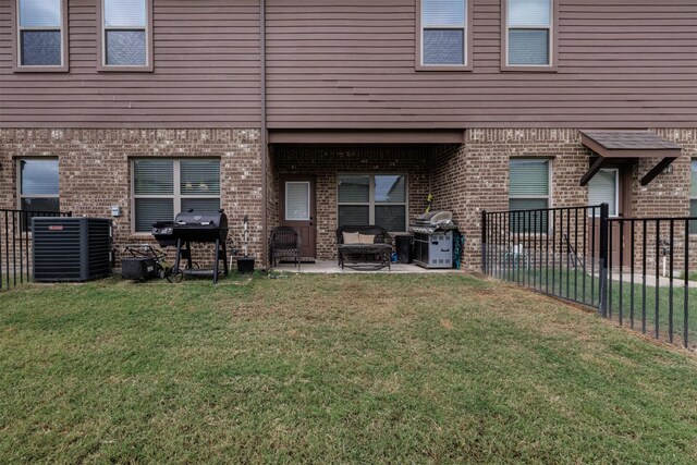 back of house with a yard, brick siding, and a patio area