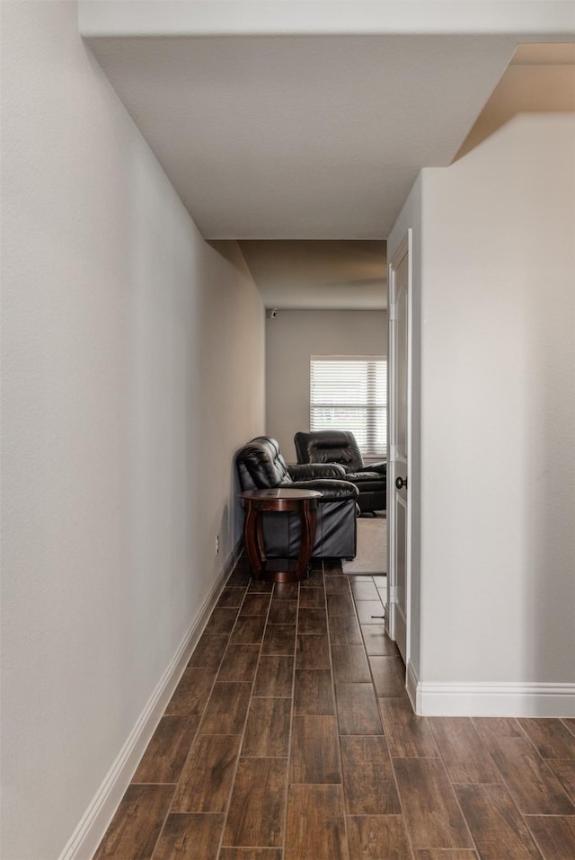 corridor featuring wood finish floors and baseboards