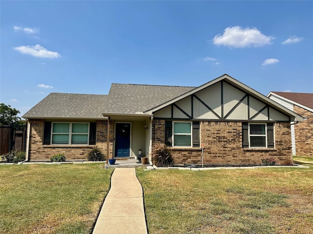 view of front of home featuring brick siding, a front lawn, and a shingled roof