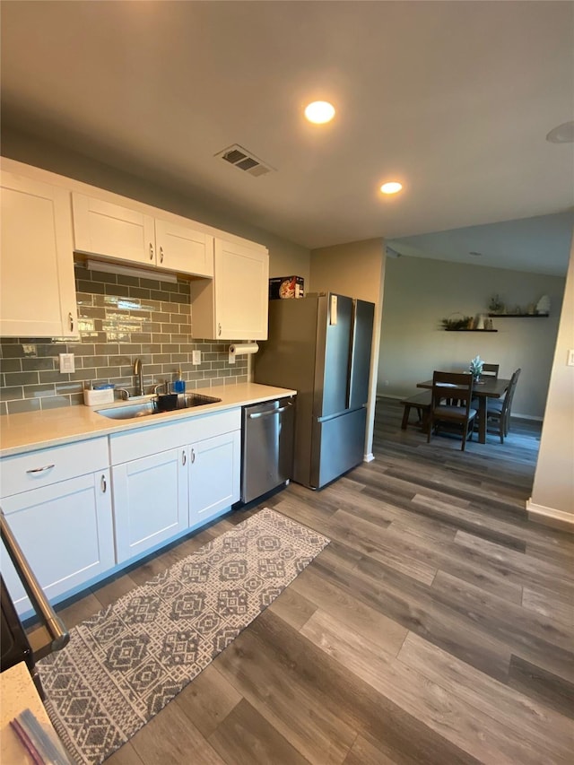 kitchen featuring a sink, dark wood-style floors, white cabinetry, appliances with stainless steel finishes, and light countertops