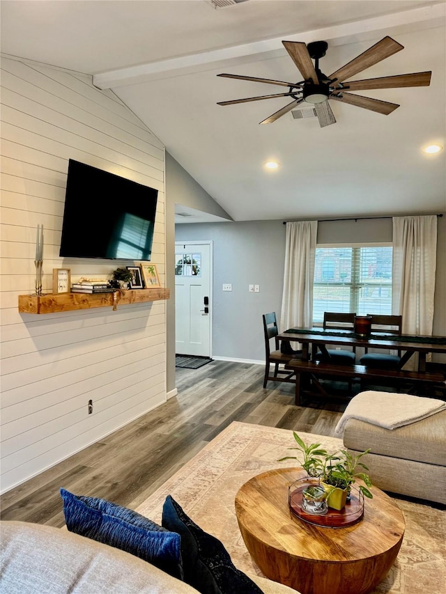 living room featuring baseboards, vaulted ceiling with beams, a ceiling fan, and wood finished floors