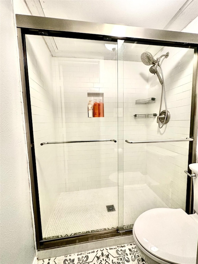 bathroom with a shower stall and toilet