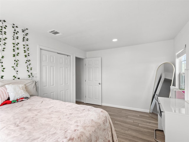 bedroom with visible vents, baseboards, light wood-type flooring, recessed lighting, and a closet