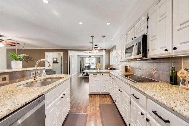 kitchen featuring a sink, stainless steel appliances, light wood-style floors, and ornamental molding