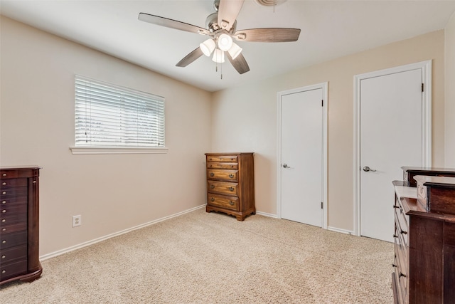 carpeted bedroom featuring baseboards and ceiling fan