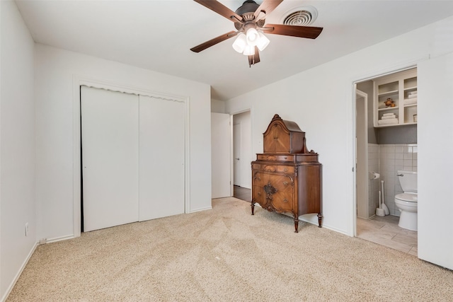 bedroom featuring visible vents, a ceiling fan, ensuite bath, a closet, and carpet flooring