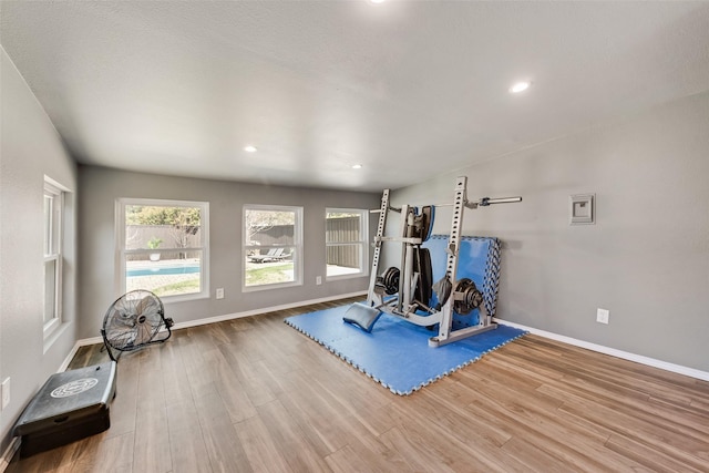 workout area with recessed lighting, baseboards, and wood finished floors