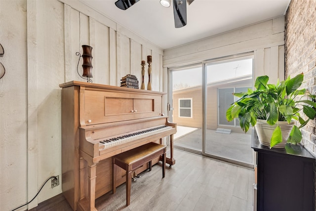 living area with light wood-type flooring and a ceiling fan