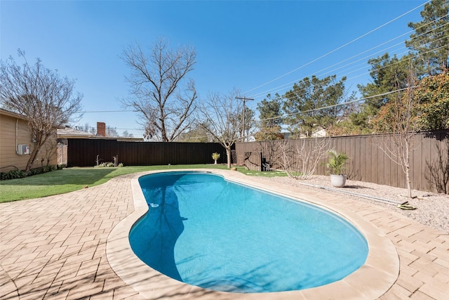 view of swimming pool featuring a yard, a fenced in pool, a patio, and a fenced backyard