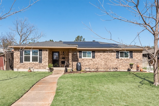 ranch-style house with a front lawn, a shingled roof, crawl space, brick siding, and solar panels