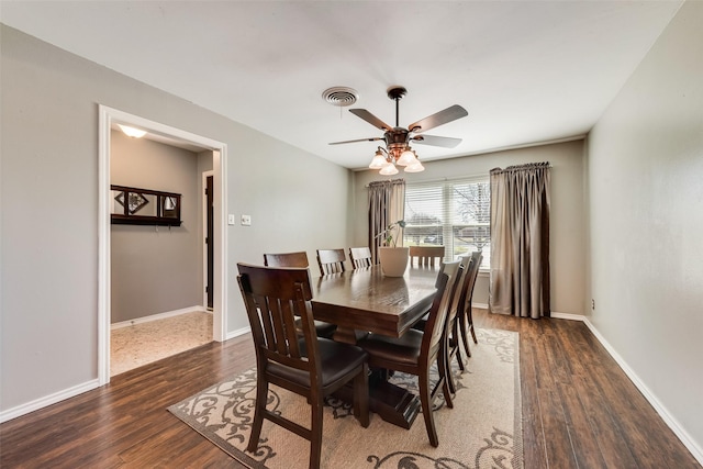 dining area with a ceiling fan, wood finished floors, visible vents, and baseboards