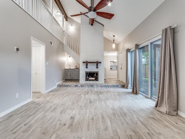 unfurnished living room featuring visible vents, baseboards, a fireplace, wood finished floors, and a ceiling fan