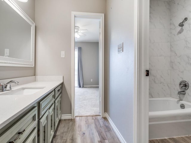 full bath with vanity, wood finished floors, baseboards, and shower / bathtub combination