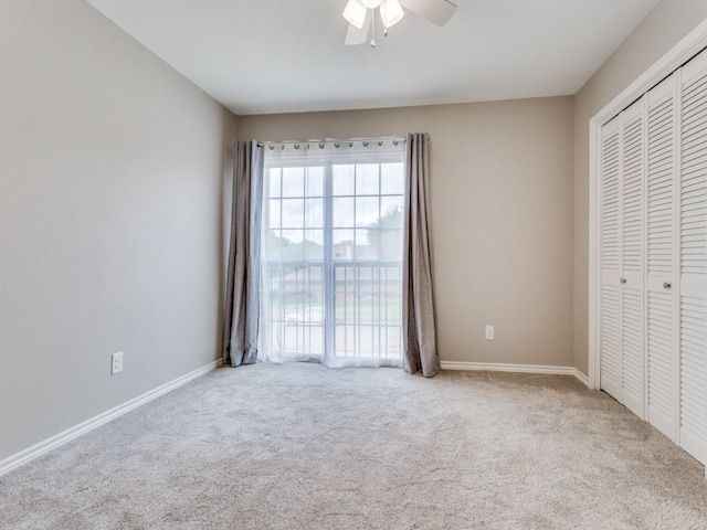 unfurnished bedroom featuring ceiling fan, carpet, a closet, and baseboards