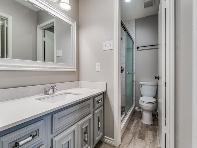 full bath featuring vanity, wood finished floors, visible vents, a shower stall, and toilet