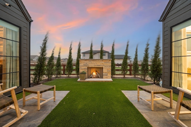 view of yard featuring an outdoor stone fireplace and a patio