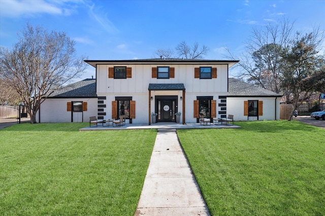 modern inspired farmhouse featuring board and batten siding, a front yard, and fence