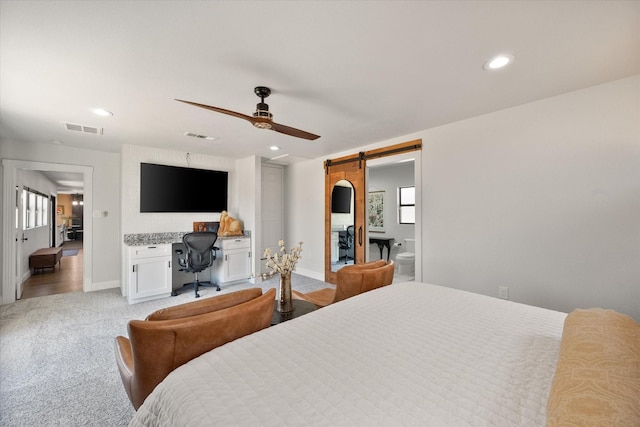 bedroom featuring visible vents, baseboards, a barn door, light carpet, and recessed lighting