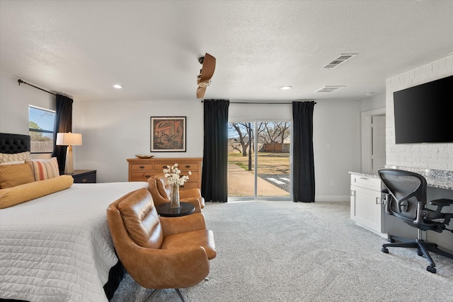 bedroom with visible vents, light colored carpet, a textured ceiling, and access to outside