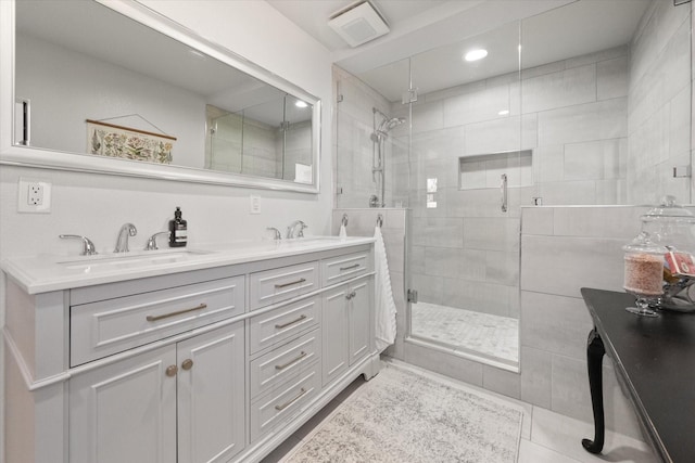 full bathroom featuring a shower stall, double vanity, tile patterned floors, and a sink