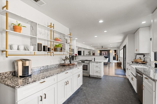 kitchen featuring visible vents, decorative backsplash, appliances with stainless steel finishes, a peninsula, and open shelves