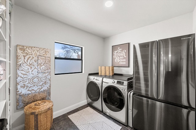 washroom featuring laundry area, independent washer and dryer, baseboards, and dark tile patterned flooring