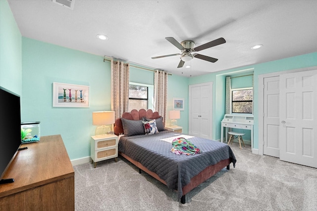 bedroom with carpet flooring, recessed lighting, baseboards, and multiple closets