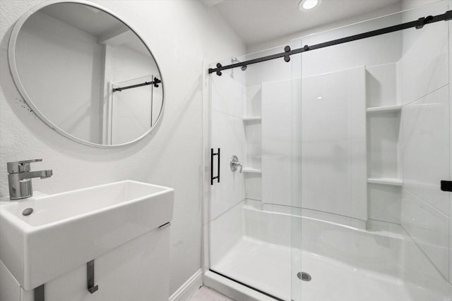 full bathroom with recessed lighting, a shower stall, and a sink