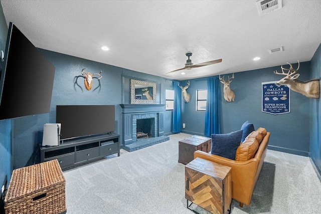 living area featuring visible vents, a brick fireplace, ceiling fan, and carpet floors