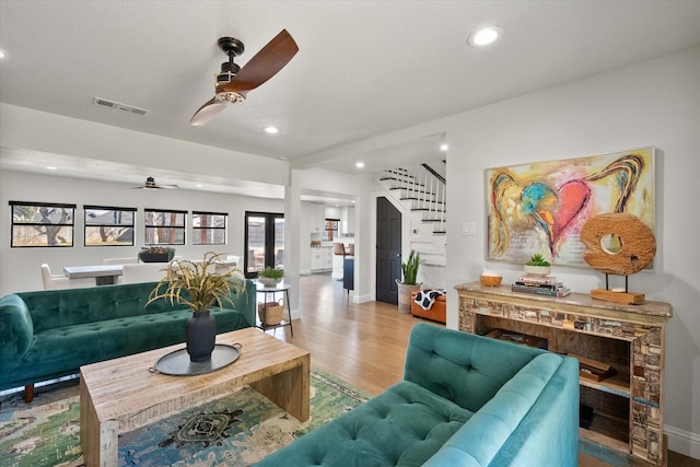 living room with stairway, a ceiling fan, wood finished floors, visible vents, and recessed lighting