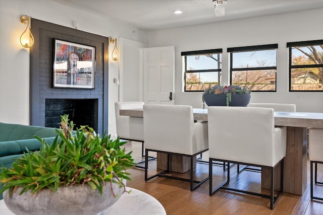 dining area featuring recessed lighting, a brick fireplace, and wood finished floors