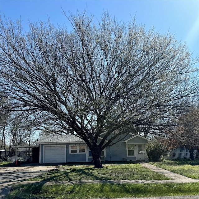 view of front of home featuring a garage, driveway, a front lawn, and fence