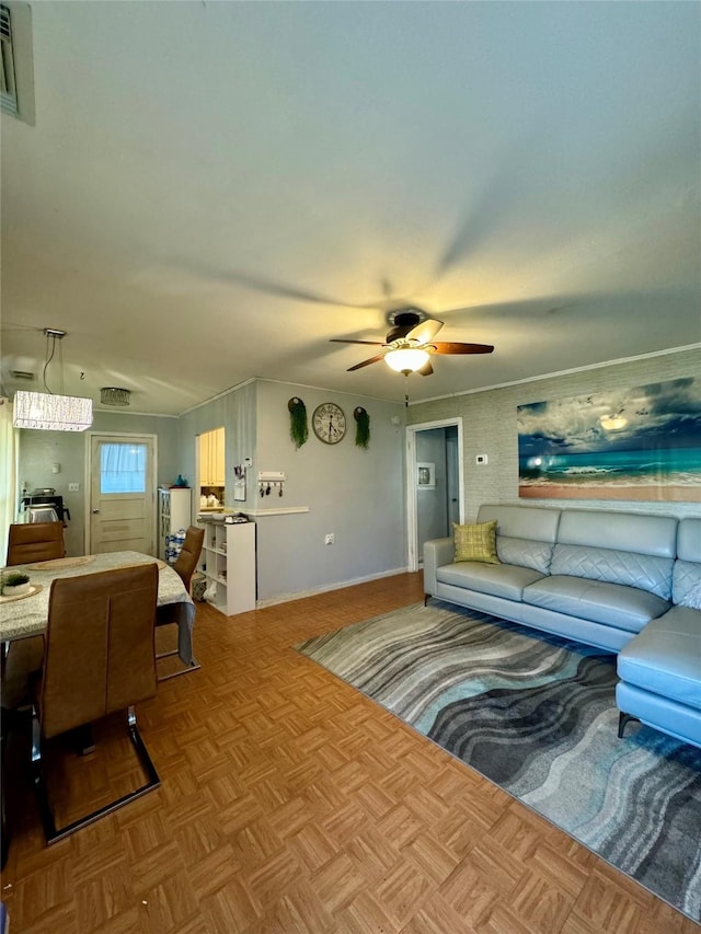 living room featuring visible vents, ornamental molding, and a ceiling fan