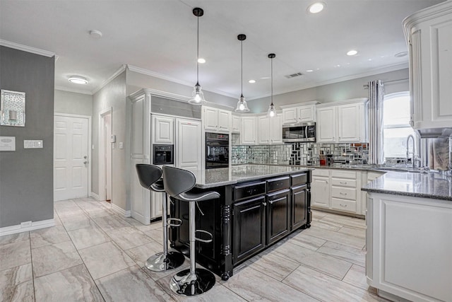 kitchen featuring white cabinetry, stainless steel microwave, dark cabinets, and oven