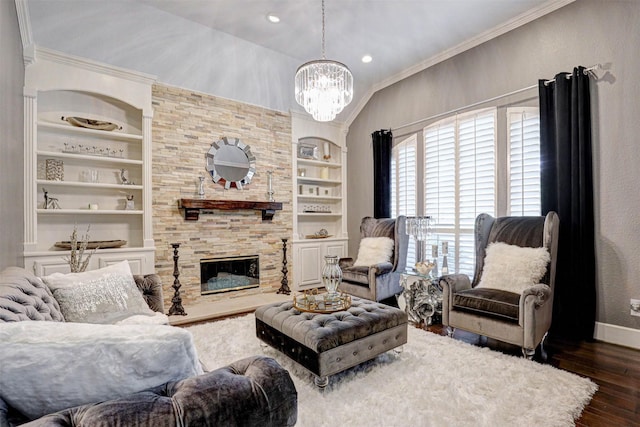 living area with built in features, a stone fireplace, wood finished floors, and crown molding