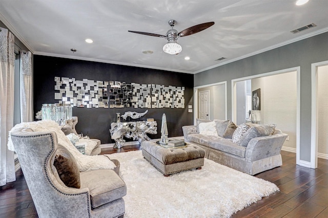 living area featuring visible vents, wood-type flooring, crown molding, baseboards, and an accent wall