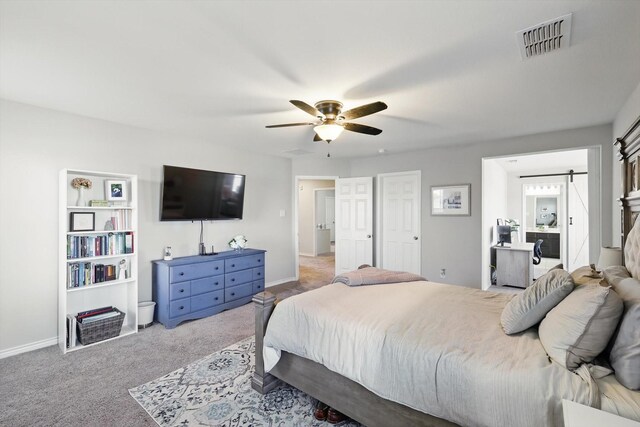 bedroom with visible vents, baseboards, a barn door, and carpet floors