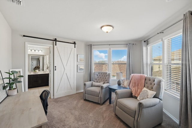 living area featuring a barn door, carpet flooring, a healthy amount of sunlight, and baseboards