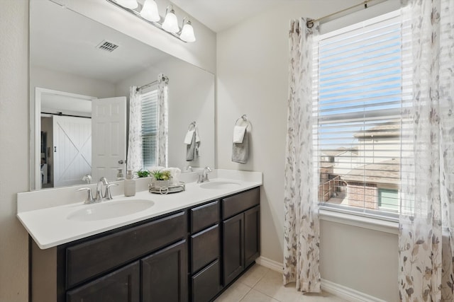 bathroom featuring tile patterned floors, double vanity, baseboards, and a sink