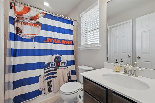 bathroom featuring toilet, vanity, and a shower with curtain